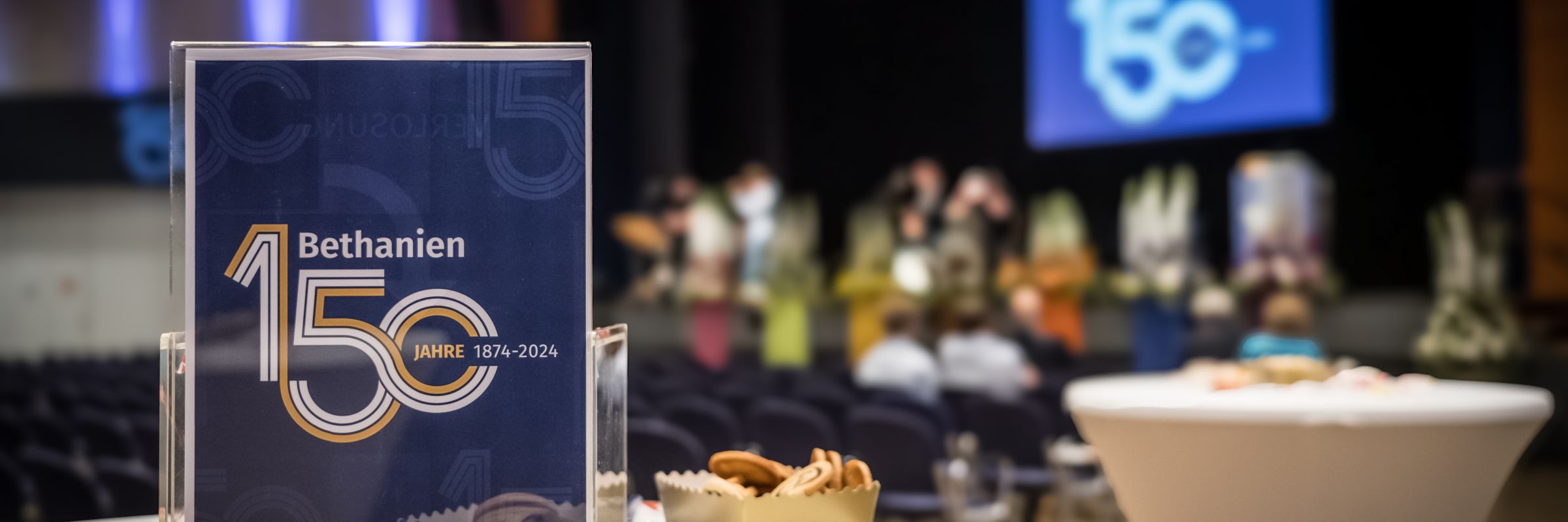 150 Jahre Bethanien Das 150 Jahre Logo im Fokus vor der Festveranstaltungs-bühne