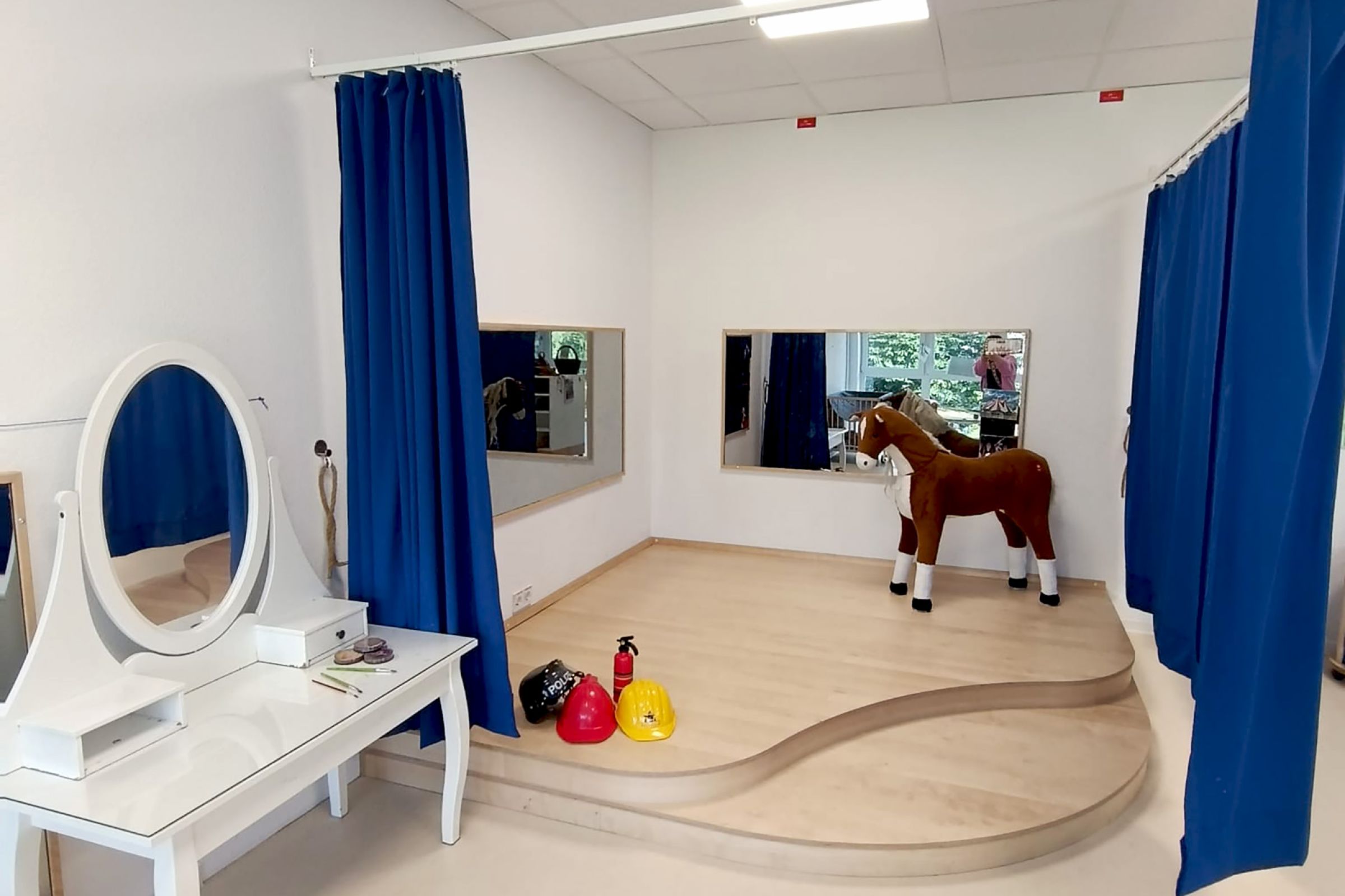 Kita Orwischer Entdecker - Verkleiden Ein Verkleidungsecke mit Spiegeln, Vorhängen, Kostümen und einem Schminktisch.