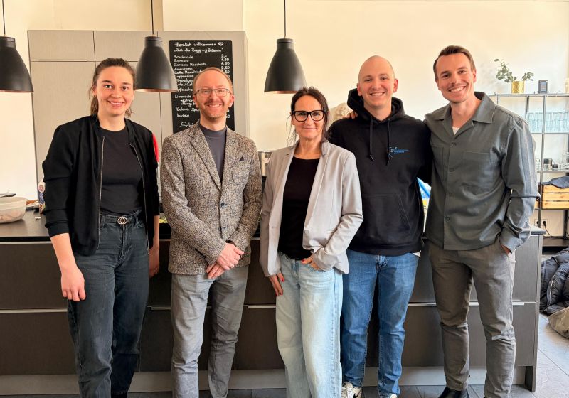 Kooperationspartner und Verantwortliche Agape Social Fünf Personen in einer Reihe posieren für ein Foto