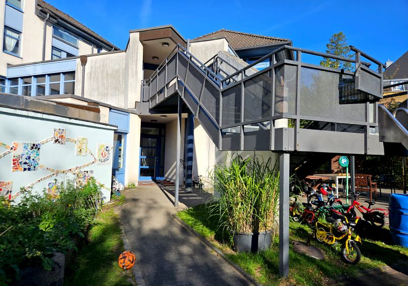 Ev. Kita Scharrenberger Straße, Solingen - Gebäude Außenansicht und Eingangsbereich der Kita Scharrenberger Straße in Solingen, mit kleinem Vorgarten und Außentreppe.