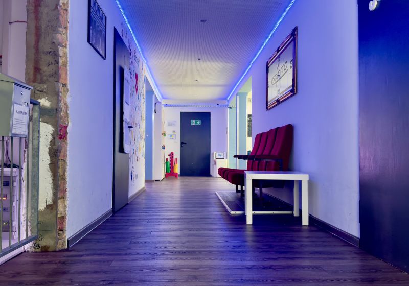 Juze Espirito - Titelbild Flur des Jugendzentrums mit Sitzmöglichkeiten und blauen Deckenlichtern